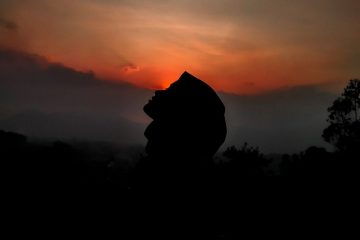 silhouette of person against sunset sky